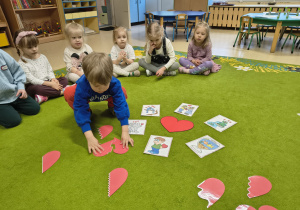 Chłopiec układa walentynkowe puzzle.