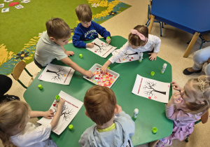 Dzieci wykonują walentynkową pracę plastyczną.