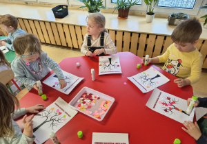 Dzieci wykonują walentynkową pracę plastyczną.