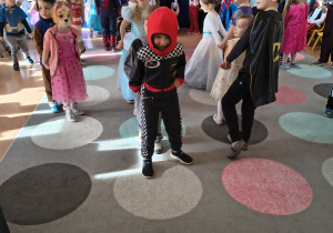 Dzieci tańczą w parach w ustawieniu jeden za drugim.