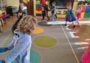 Dzieci naśladują w parach jazdę saneczkami.