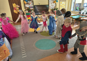 Dzieci tańczą w kole.