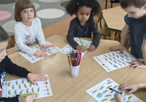 Dzieci kolorują pączki wedłg podanego kodu.