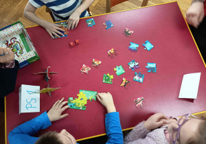 Dzieci grają w grę planszową Dinozaury.