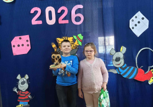 Dzieci na zdjęciu pamiątkowym z dyplomami i nagrodami.