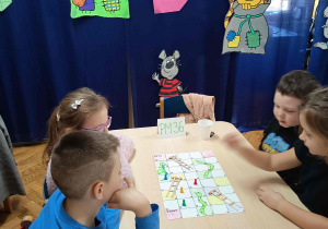 Dzieci uczestniczą w grze planszowej -Wąż