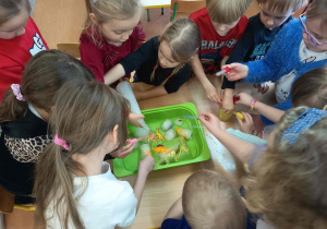 Zabawa badawcza - dzieci obserwują topnienie lodu.