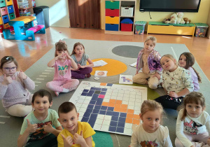 Zdjęcie grupowe po ułożeniu zakodowanego obrazka dinozaura.