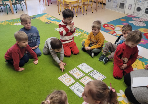 Dzieci oglądają ilustracje zwierząt.