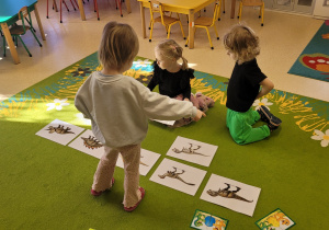 Dzieci łączą w pary sylwety dinozaurów z odpowiednimi szkieletami.