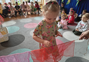 Dziewczynka przypina klamerkę do sznurka.