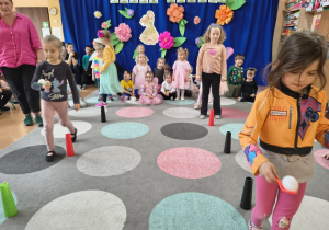 Dziewczynki idą po wyznaczonym torze niosąc jajko na łyżce.