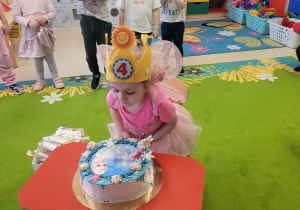 Julcia zdmuchuje świeczkę na torcie.