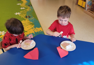 Chłopcy jedzą tort.