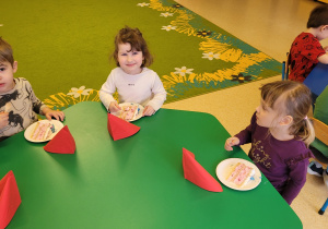 Dzieci jedzą tort owocowy.