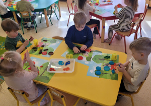 Dzieci uczestniczą w zabawach manualnych z wykorzystaniem ciastoliny.