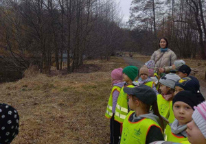 Dzieci w parku oglądają pierwsze oznaki wiosny.