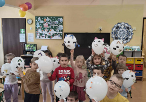Dzieci prezentują swoje koty z balonów.