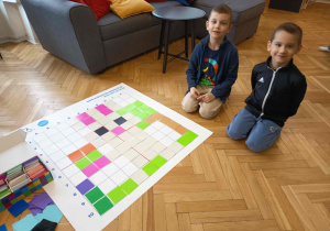 Chłopcy prezentują obrazek zajączka na macie do kodowania.