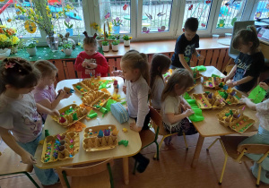 Dzieci tworzą wielkanocne koszyczki.
