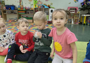 Chłopiec dmucha na śnieg i sprawdza czy ten stopnieje.