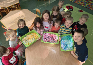 Dzieci prezentują pomalowany przez nie śnieg.