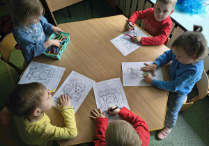 Dzieci kolorują obrazki związane z obchodami światowego dnia świadomości autyzmu.
