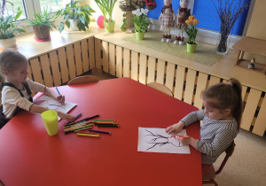 Dziewczynki wykonują pracę plastyczną.