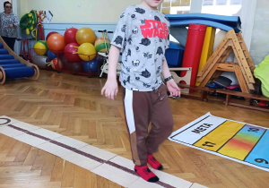 Chłopiec przechodzi przez ścieżkę sensoryczną.