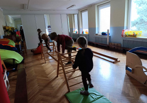 Dzieci przechodzą po drabinkach na wysokości.