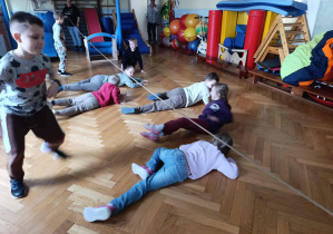 Dzieci przechodzą pod liną.