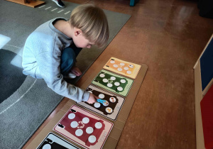 Dzieci uczestniczą w zabawie edukacyjnej, która uczy sortowania odpadów.