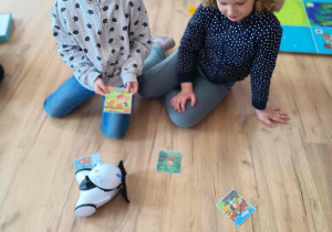 Dzieci bawią się kartami edukacyjnymi i robotami.