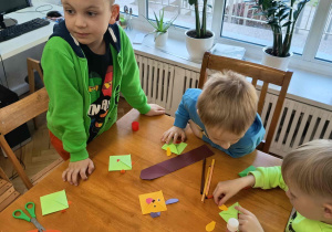 Chłopcy zajmują się tworzeniem figurek z papieru przy użyciu techniki origami.