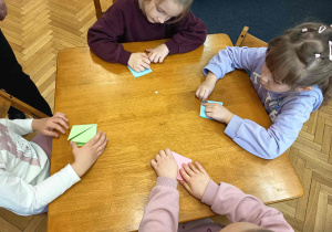 Dzieci uczestniczą w twórczej zabawie - składanie origami.