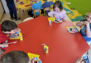 Dzieci jedzą tort urodzinowy od Julka.