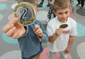 Chłopcy z papierowym bilonem 2 złotych.