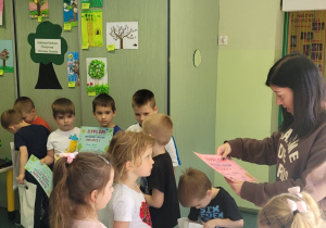 Nauczycielka wręcza dziewczynkom dyplomy.