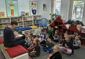 Bibliotekarz czyta dzieciom książkę.