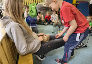 Chłopiec dotyka futerka surykatki.
