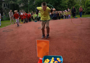 Chłopiec przekłada koło hula hop.