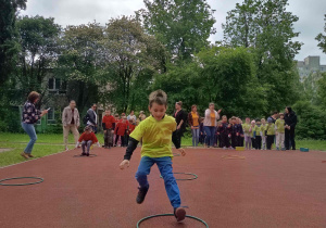 Chłopiec wskakuje do koła hula hop.