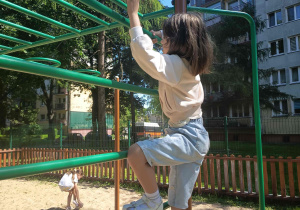 Dziewczynka wspina się na drabinkę.