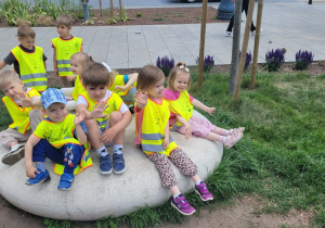 Dzieci odpoczywają na ozdobnym kamieniu.