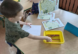 Dzieci rozwiązują karty pracy.