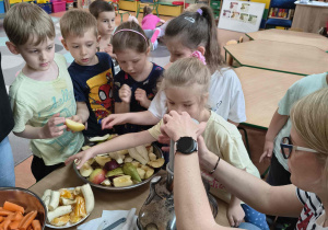 Dzieci wspólnie z mamą Łukasza robią sok owocowo-warzywny.