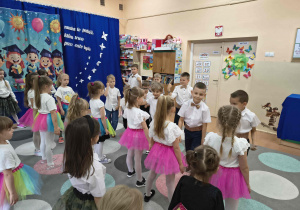 Dziewczynki tańczą z chłopcami taniec na pożegnanie.