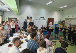 Rodzice oglądają występ artystyczny swoich dzieci.