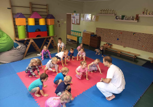 Dzieci podpieraja się na dłoniach i stopach, uważnie obserwując instruktora i czekając na kolejne polecenia.