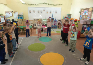 Dzieci uczestniczą w zabawach ruchowych z kolorowymi kropkami.